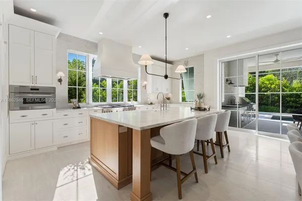 a dining room with furniture a chandelier and wooden floor