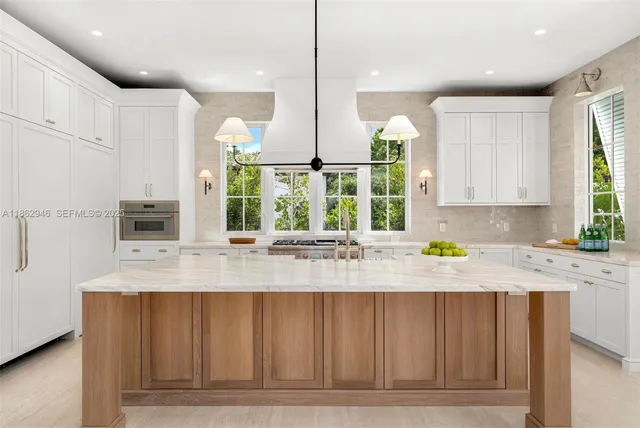 a kitchen with kitchen island granite countertop a sink cabinets and window