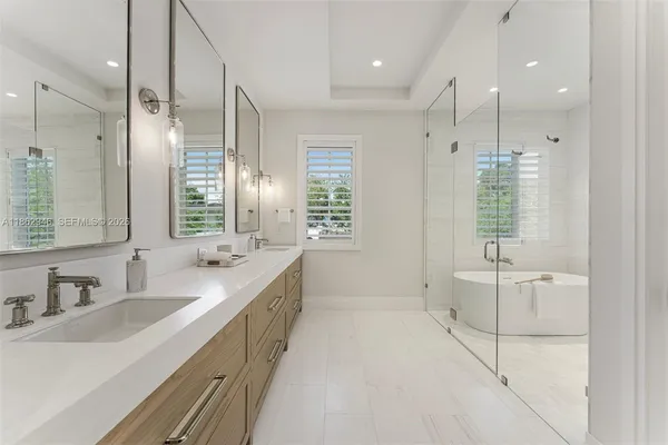 a kitchen with stainless steel appliances kitchen island granite countertop a dining table chairs and white cabinets