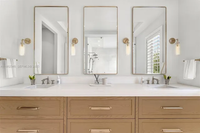 a bathroom with double vanity sinks and a mirror