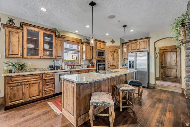 9049 Timphaven Road Sundance, UT 84604 - Photo 9 of 63 Kitchen featuring stainless steel appliances, wood finish cabinets, pendant lighting, a center island, and light stone countertops