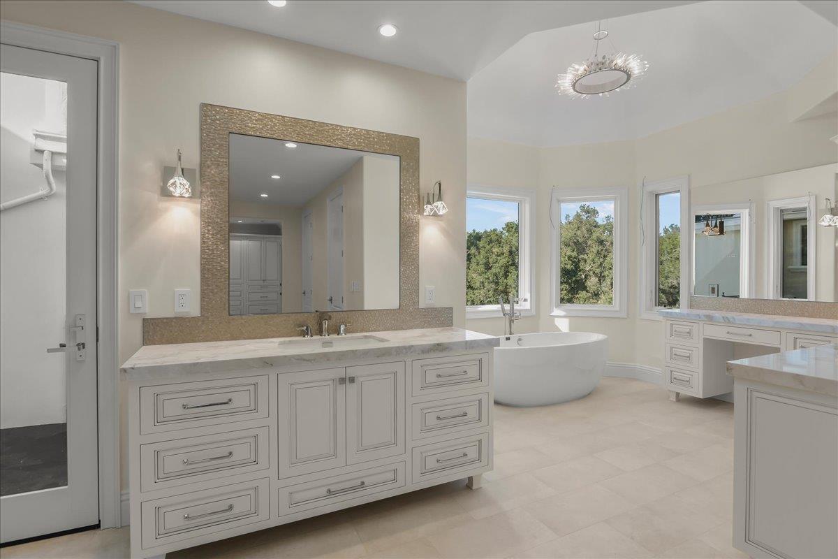 18911 Decatur Road Los Gatos, CA 95030 - Photo 60 of 143 a bathroom with a granite countertop sink a large mirror a bathtub and next to a window