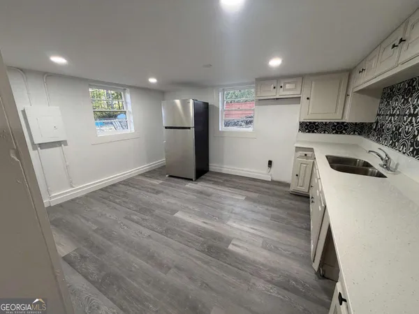 a kitchen with granite countertop a sink and a refrigerator