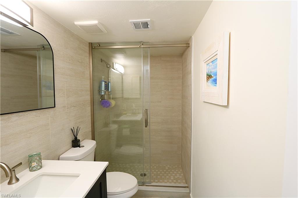 2235 San Marco Road, Unit 5204 Marco Island, FL 34145 - Photo 22 of 42 Full bathroom with a shower stall, vanity, and tile walls