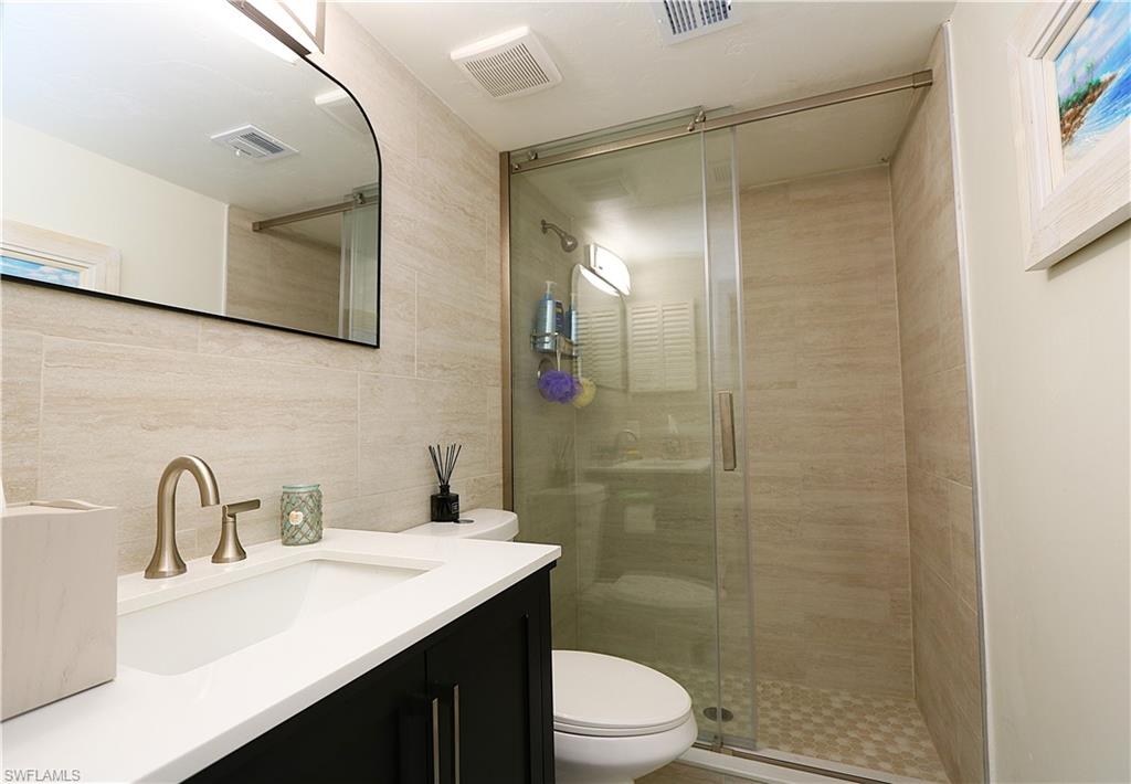 2235 San Marco Road, Unit 5204 Marco Island, FL 34145 - Photo 23 of 42 Full bath with vanity, tile walls, and a shower stall