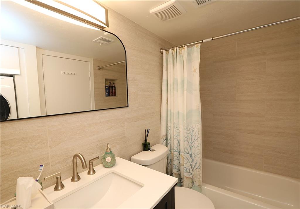 2235 San Marco Road, Unit 5204 Marco Island, FL 34145 - Photo 27 of 42 Full bath featuring tile walls, shower / bathtub combination with curtain, vanity, and backsplash