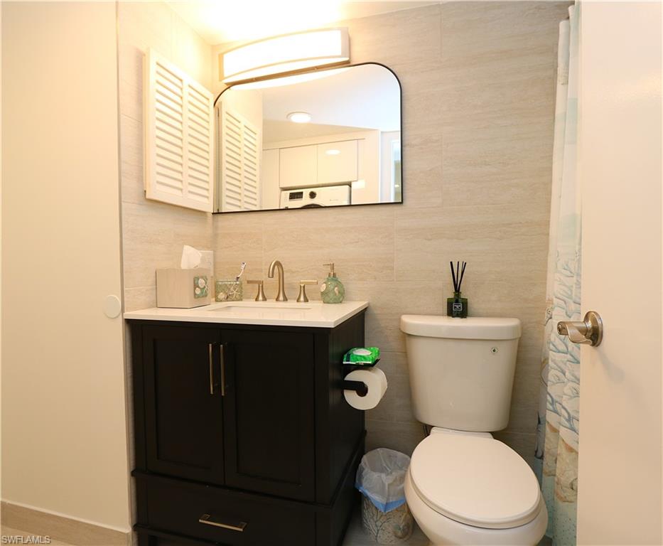 2235 San Marco Road, Unit 5204 Marco Island, FL 34145 - Photo 28 of 42 Full bathroom featuring vanity and tile walls