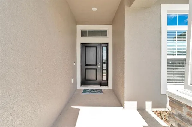 a view of a hallway with wooden floor and a livingroom