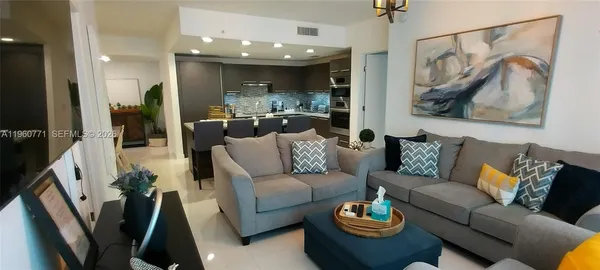 a living room with furniture and a painting on the wall