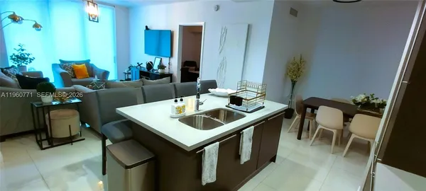 a living room with stainless steel appliances kitchen island granite countertop furniture and a kitchen view