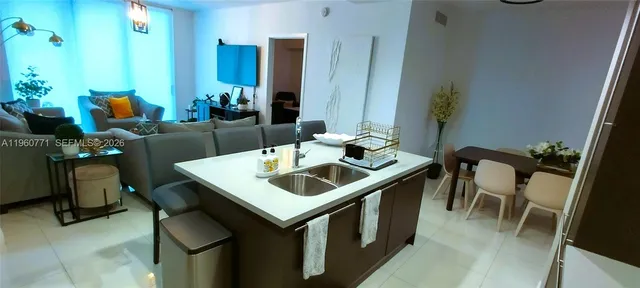 a living room with stainless steel appliances kitchen island granite countertop furniture and a kitchen view