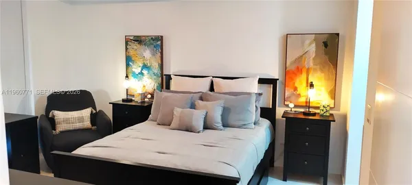 a bedroom with a bed and a flat screen tv