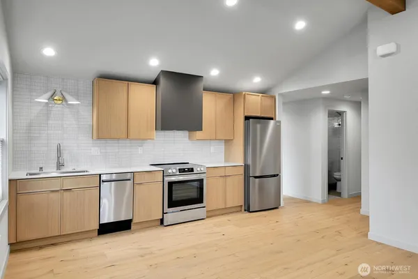 a kitchen with stainless steel appliances granite countertop a refrigerator sink and stove