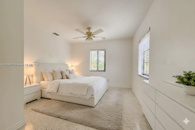 a bedroom with a large bed chandelier and a window