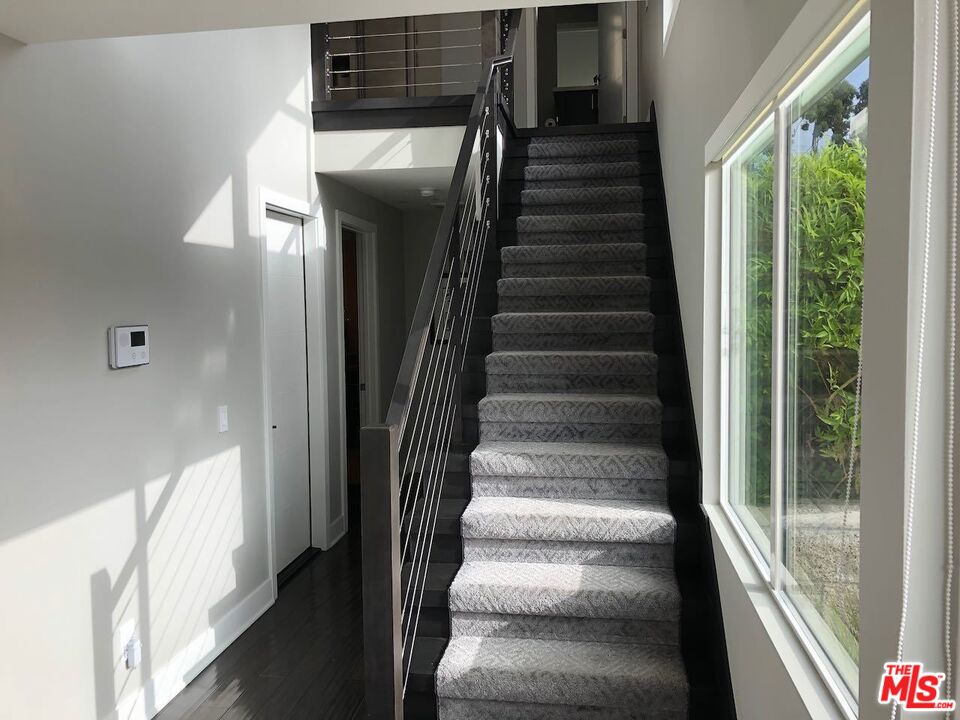 12003 Emery Lane Valley Village, CA 91607 - Photo 14 of 22 a view of staircase with lots of frames on wall and windows