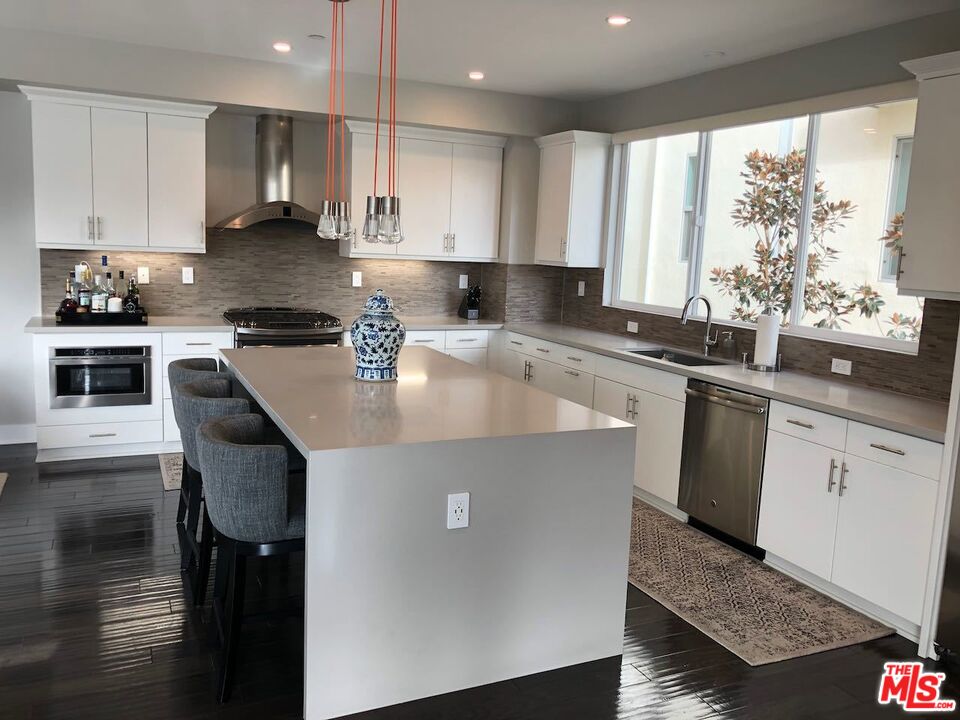 12003 Emery Lane Valley Village, CA 91607 - Photo 5 of 22 a kitchen with a sink a stove a refrigerator and cabinets