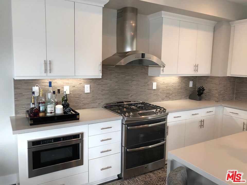 12003 Emery Lane Valley Village, CA 91607 - Photo 6 of 22 a kitchen with a stove and white cabinets