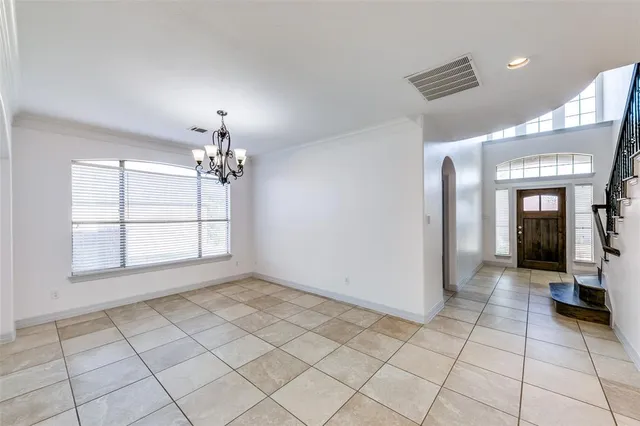 a view of a room with a chandelier fan and windows