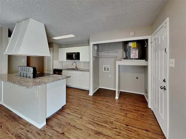 a living room with stainless steel appliances kitchen island granite countertop a stove a sink a refrigerator and cabinets