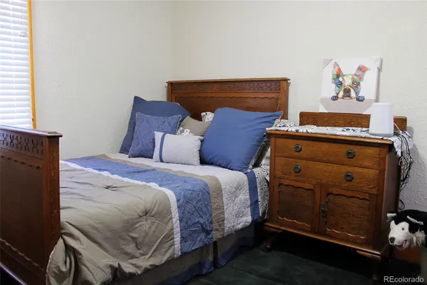 a bedroom with a bed and painting on the wall