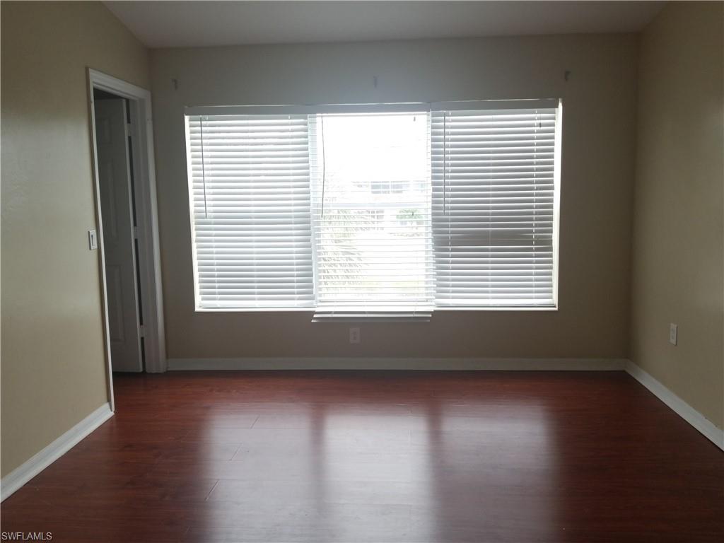 988 Hampton Circle, Unit 73 Naples, FL 34105 - Photo 13 of 22 a view of an empty room with wooden floor and a window