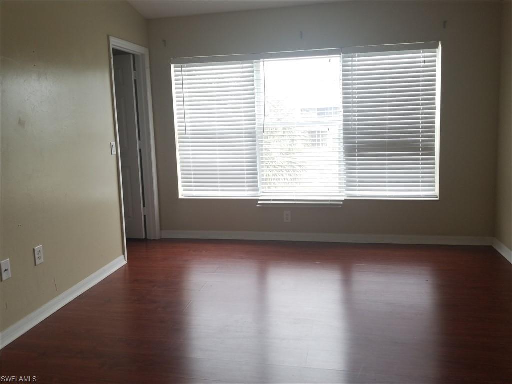 988 Hampton Circle, Unit 73 Naples, FL 34105 - Photo 15 of 22 a view of an empty room with wooden floor and a window
