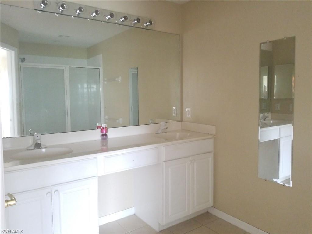 988 Hampton Circle, Unit 73 Naples, FL 34105 - Photo 16 of 22 a bathroom with a double vanity sink and mirror
