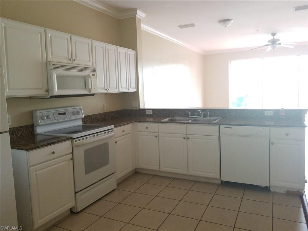 988 Hampton Circle, Unit 73 Naples, FL 34105 - Photo 7 of 22 a kitchen with white cabinets