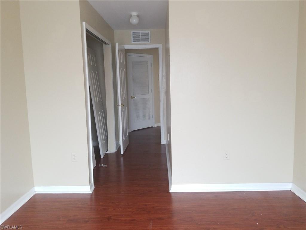 988 Hampton Circle, Unit 73 Naples, FL 34105 - Photo 9 of 22 a view of a hallway with wooden floor