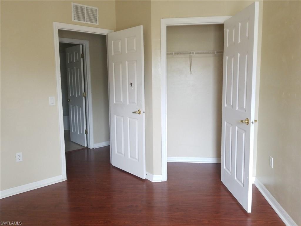 988 Hampton Circle, Unit 73 Naples, FL 34105 - Photo 10 of 22 an empty room with wooden floor & closet area
