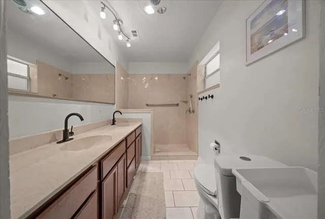 a bathroom with a sink double vanity granite tub shower and mirror