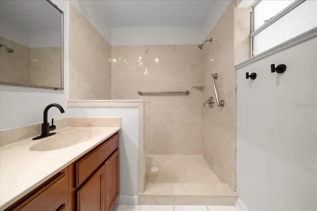 a bathroom with a sink a shower and mirror