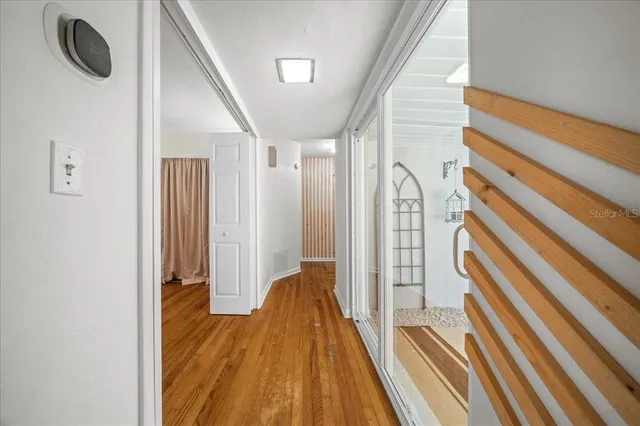 a view of a hallway with wooden floor and staircase
