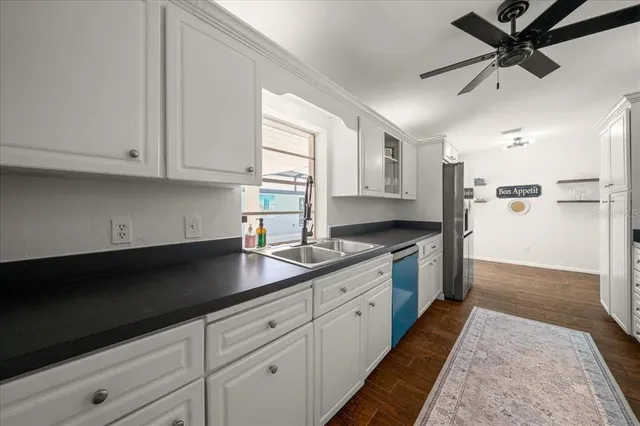 a kitchen with granite countertop a sink stainless steel appliances and cabinets
