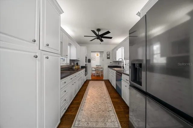 a kitchen with stainless steel appliances a refrigerator sink and cabinets