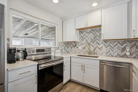 a kitchen with white cabinets and appliances