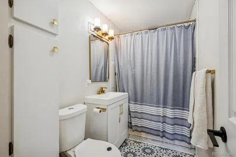 a bathroom with a sink a toilet and shower curtain