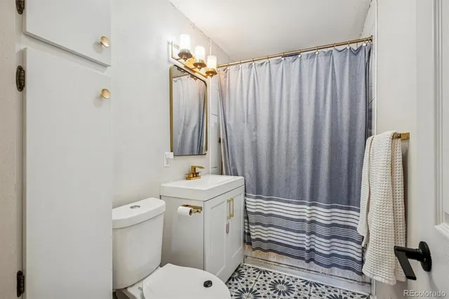 a bathroom with a sink a toilet and shower curtain