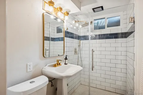 a bathroom with a sink a toilet and shower