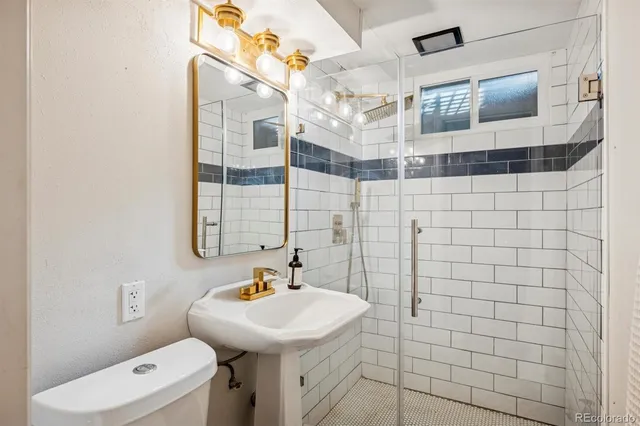 a bathroom with a sink a toilet and shower