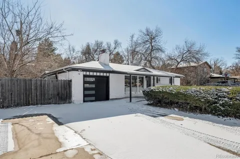 a front view of a house with a garden and trees