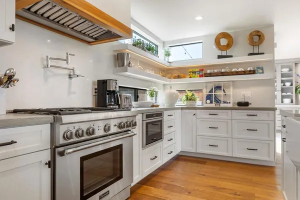 a kitchen with cabinets stainless steel appliances and wooden floor