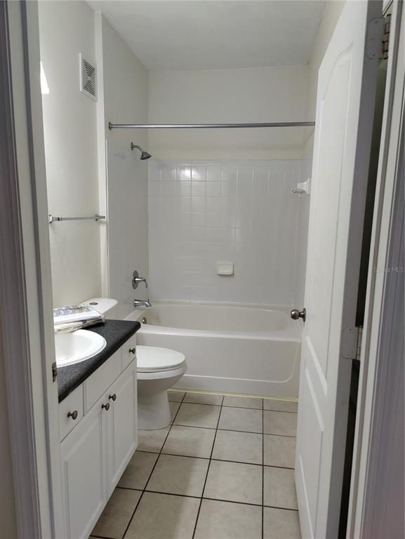 8813 Villa View Circle, Unit 104 Orlando, FL 32821 - Photo 5 of 14 a bathroom with a granite countertop sink toilet and shower