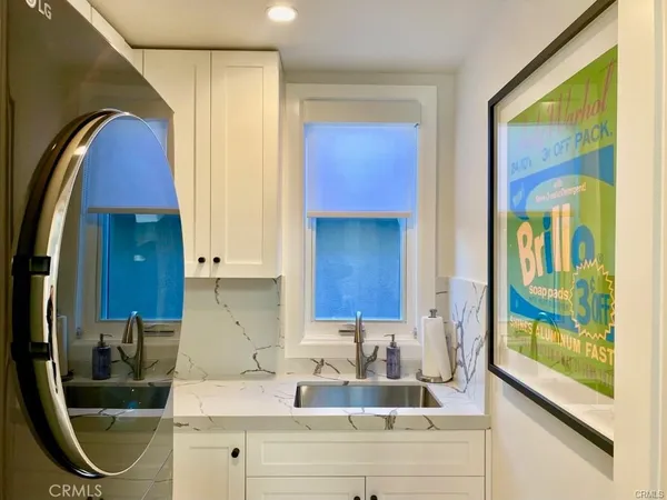 a kitchen with a sink a counter top space cabinets and a window