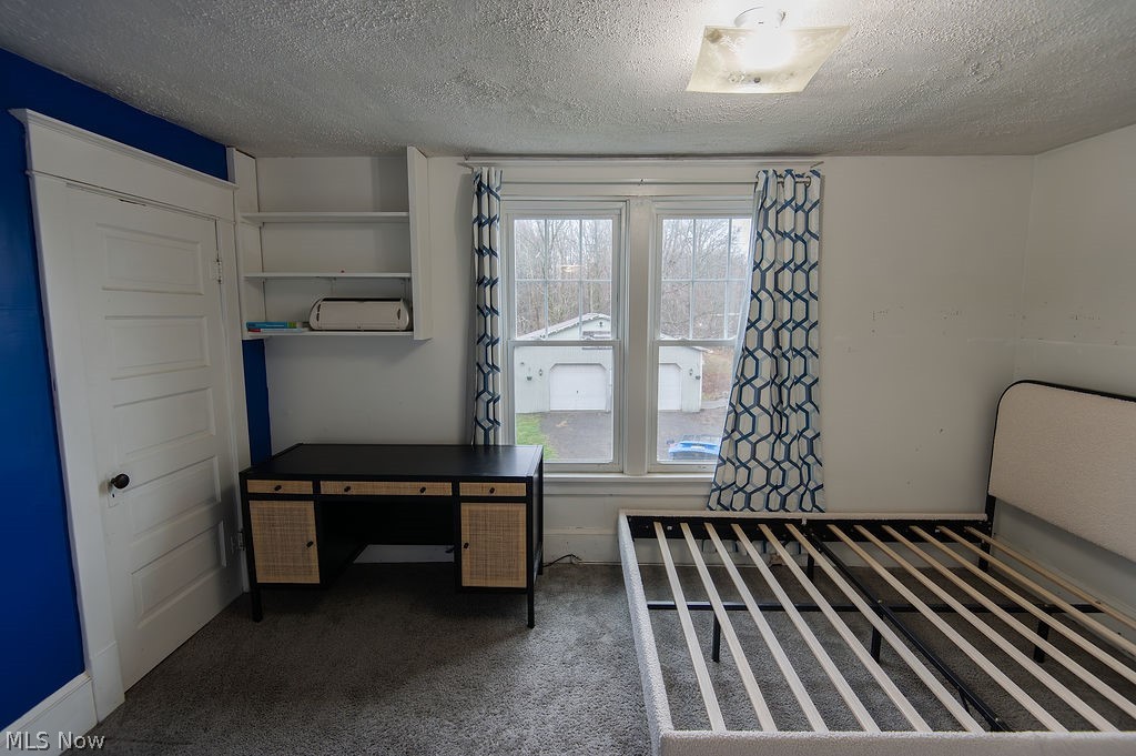1195 South Johnson Road Sebring, OH 44672 - Photo 21 of 34 Bedroom with dark carpet and a textured ceiling