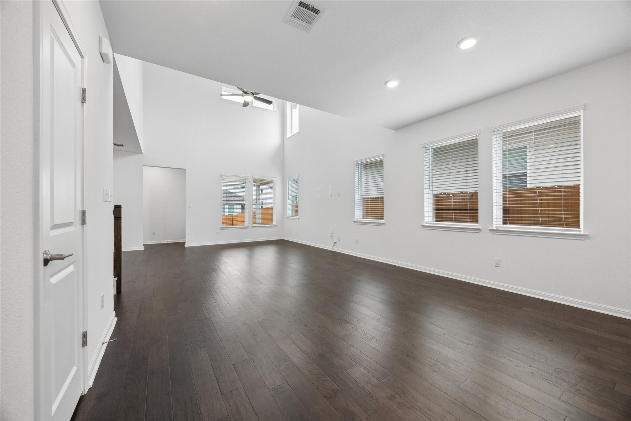 6407 Rounded Pebble Lane Buda, TX 78610 - Photo 3 of 32 An airy living space features soaring ceilings, a ceiling fan, and rich hardwood flooring.