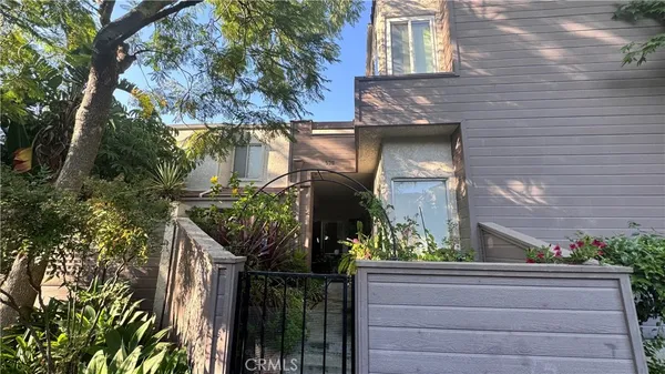 a front view of a house with a tree