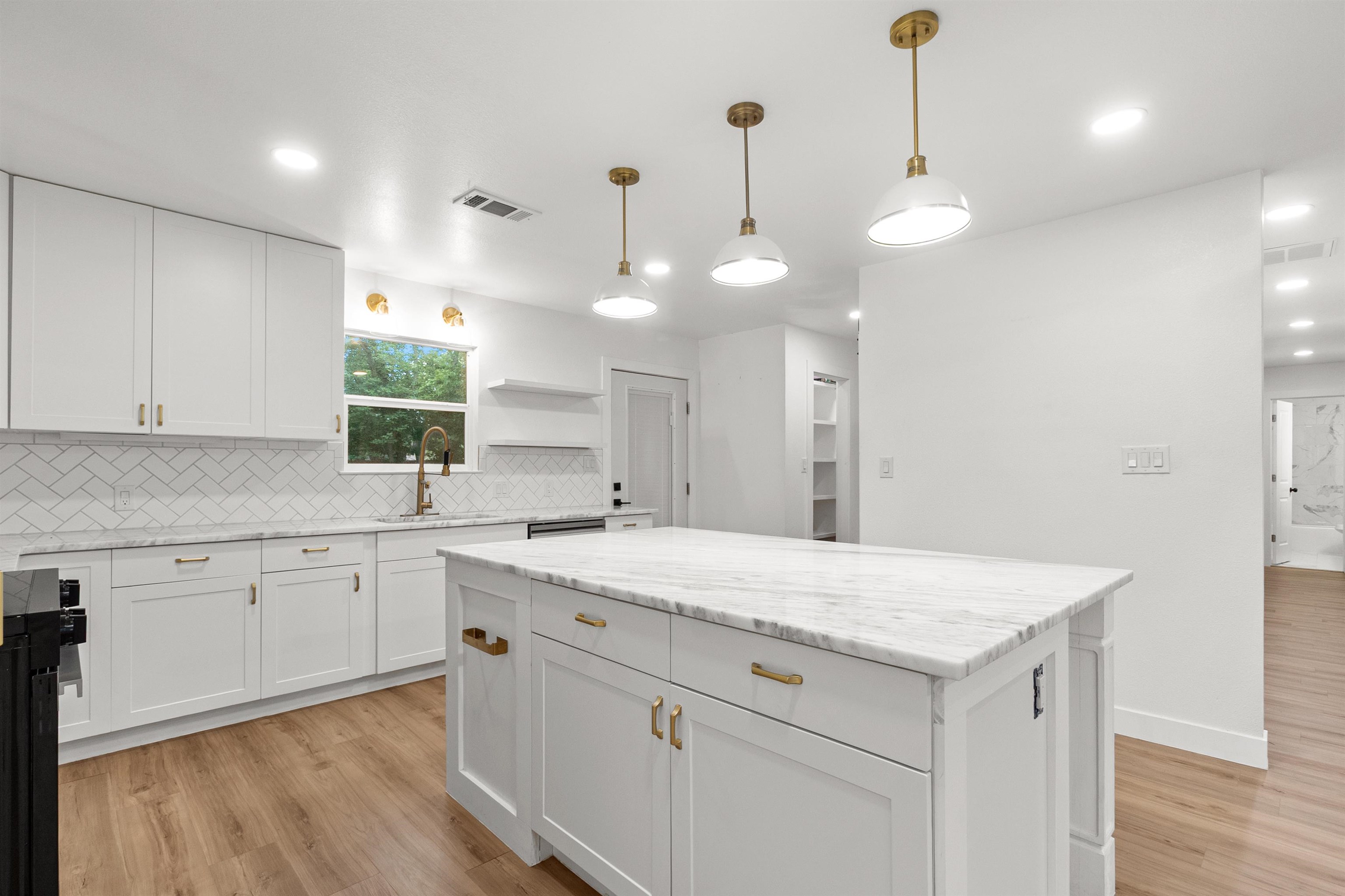 409 Ave R Marble Falls, TX 78654 - Photo 9 of 20 a kitchen with a sink chandelier and wooden floor