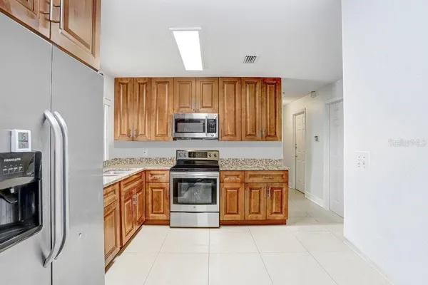 a kitchen with stainless steel appliances granite countertop a stove a sink and a refrigerator