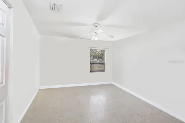 an empty room with a window and a ceiling fan